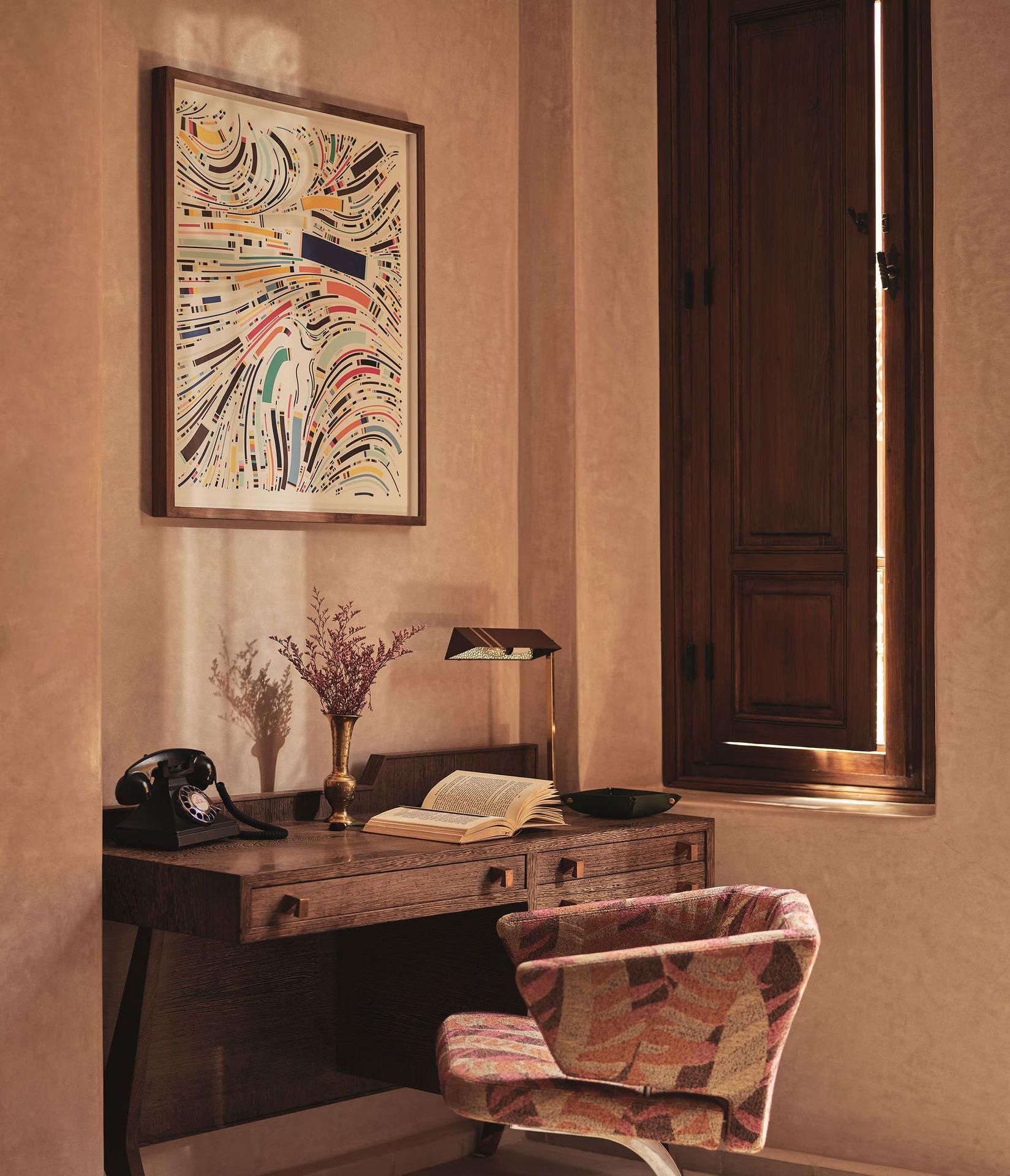 Wooden desk with artwork and chair