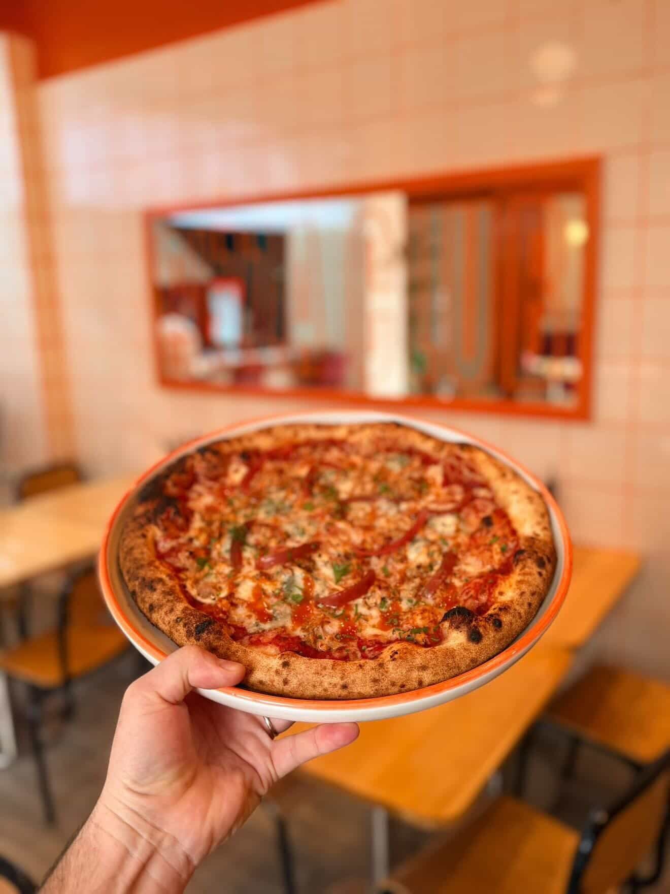 A loaded pizza with greens at Pizzaclub
