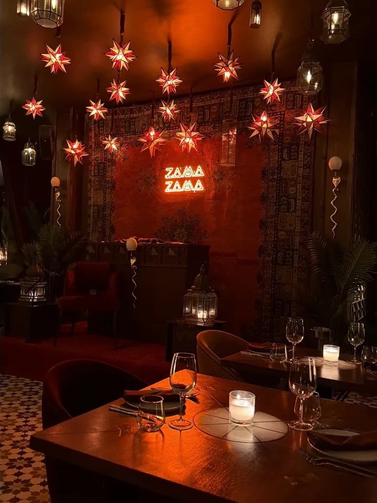 Star lights and the Zama Zama neon sign over a table