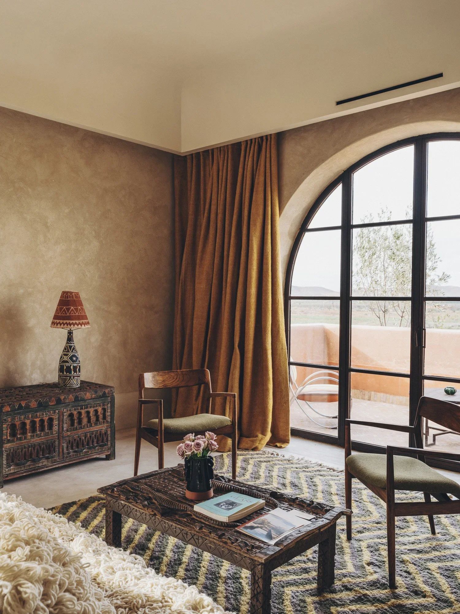 Mustard curtains and the salon's arched window