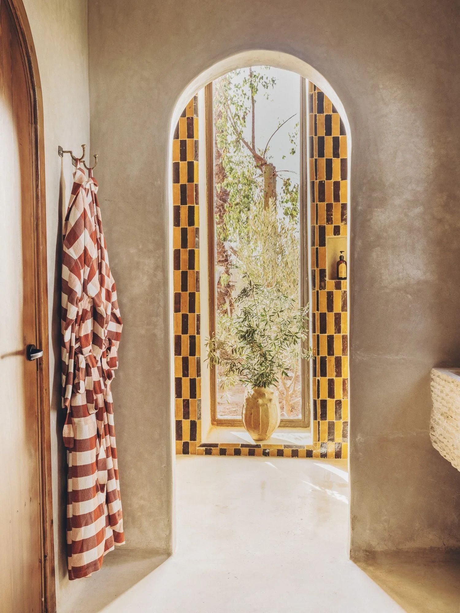The bed framed by reed screens and a checked Beni rug